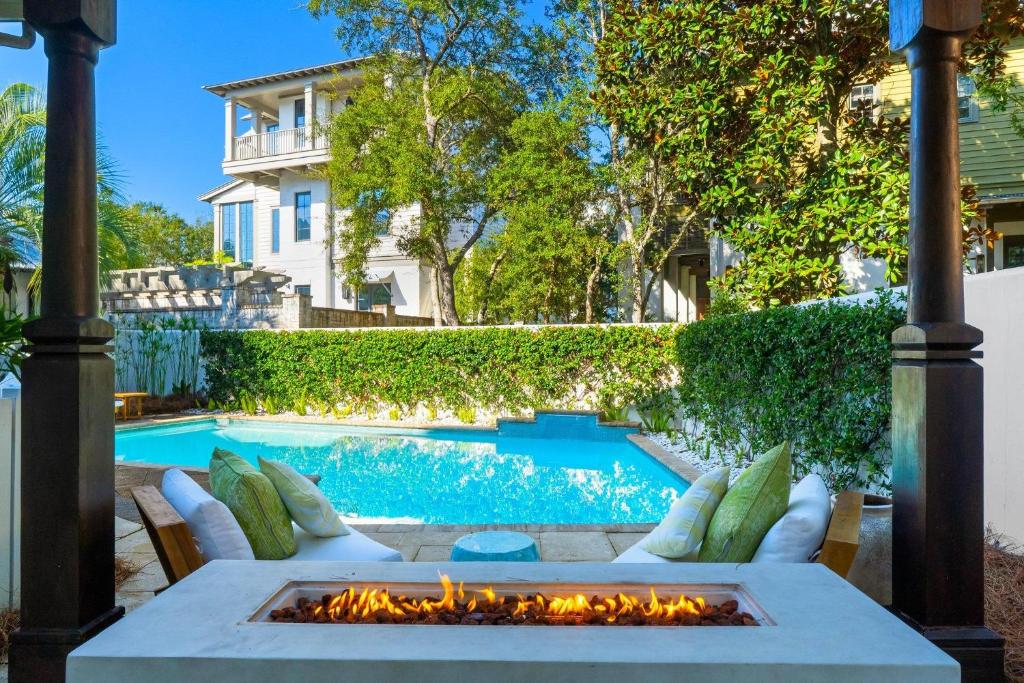 a fire pit in front of a swimming pool at Serenity Now in Rosemary Beach
