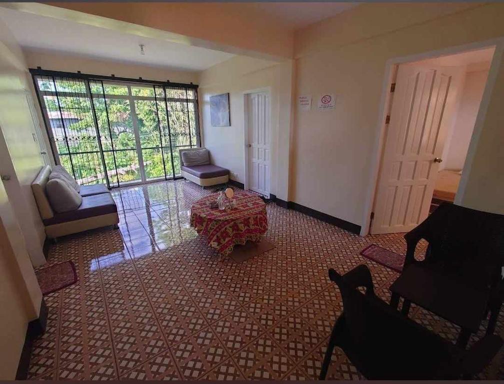 a large living room with a table and a window at JMC1 Room1 Tagbilaran City Bohol in Tagbilaran City