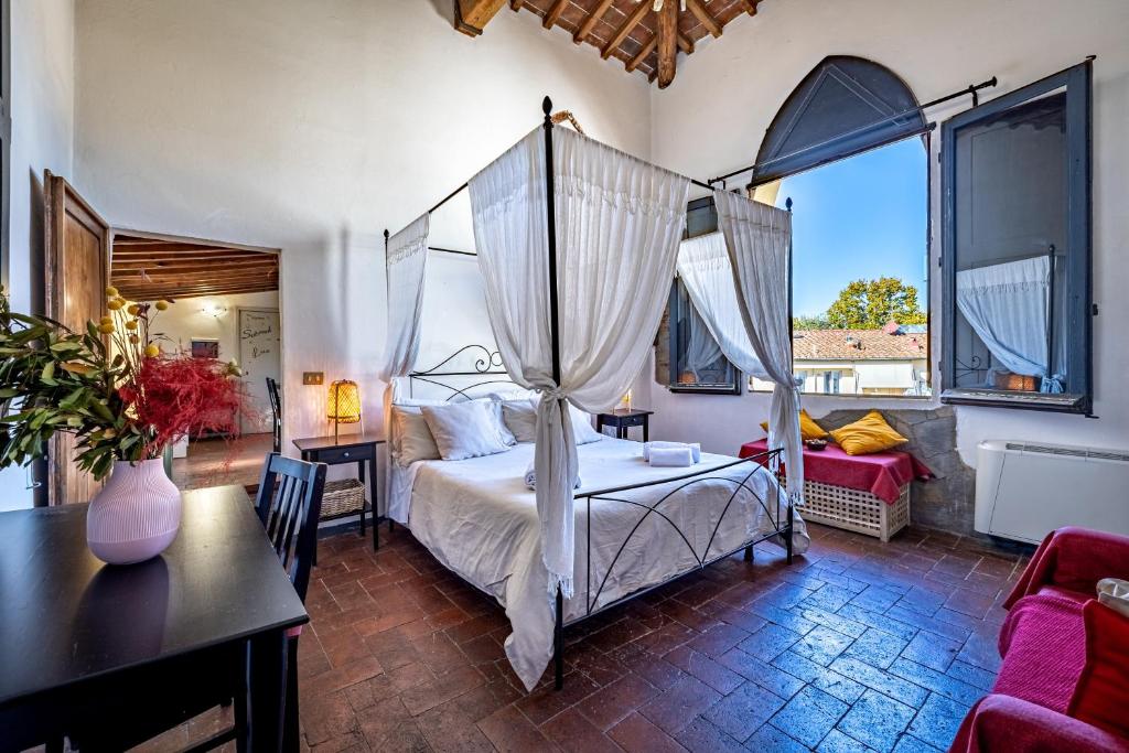 - une chambre avec un lit à baldaquin, une table et des chaises dans l'établissement Il Magnifico Firenze, à Florence