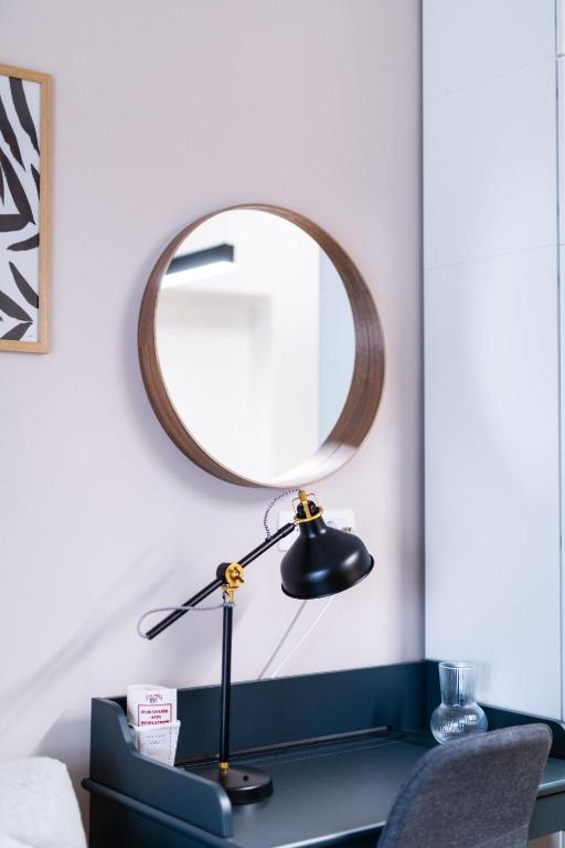 a desk with a lamp and a mirror on it at Studio apartman Kvaternik in Zagreb