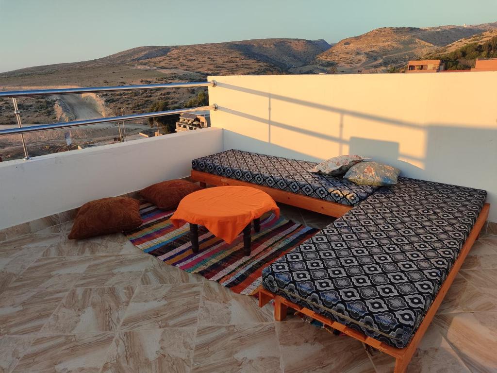 a balcony with a bench and a table and a view at Sea Breeze in Imsouane