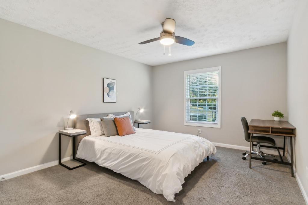 Un dormitorio blanco con una cama y un escritorio. en Barcelo At East Cobb Q1 1 Bed 1 Bath Furnished, en Marietta