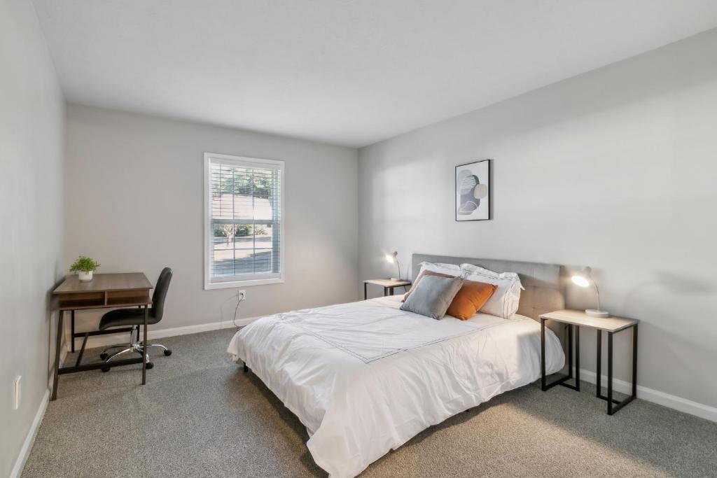 Un dormitorio blanco con una cama y un escritorio. en Barcelo At East Cobb Q7 1 Bd 1 Bth Furnished, en Marietta