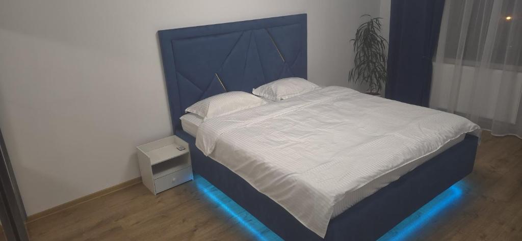 a bed with a blue headboard in a room at Melissa Home in Bucharest