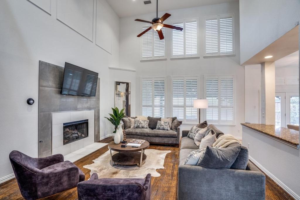 a living room with a couch and a fireplace at 5Br Lux! Pool, Games & Theater in Rowlett