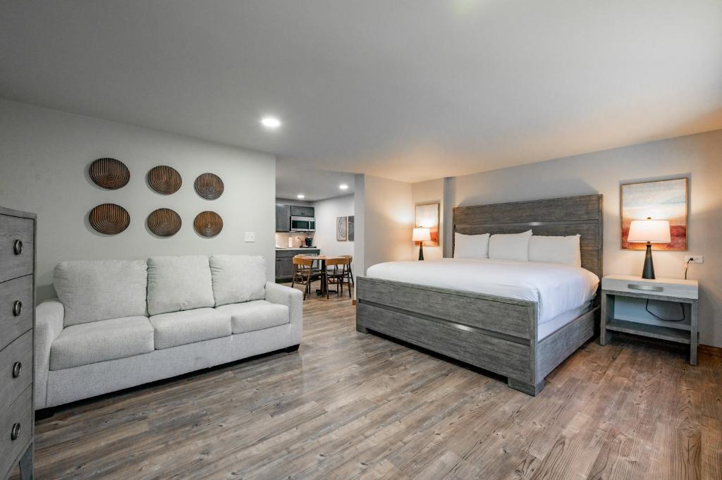 een slaapkamer met een bed en een bank bij Cove Creek Lodge 107 Lakeside Executive King Suite in Oakland