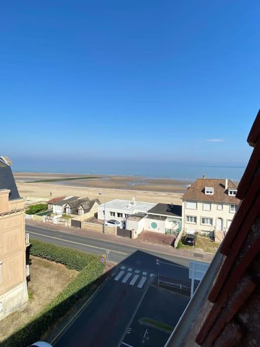 - une vue sur une rue avec des maisons et l'océan dans l'établissement Le phare de Villers, à Villers-sur-Mer