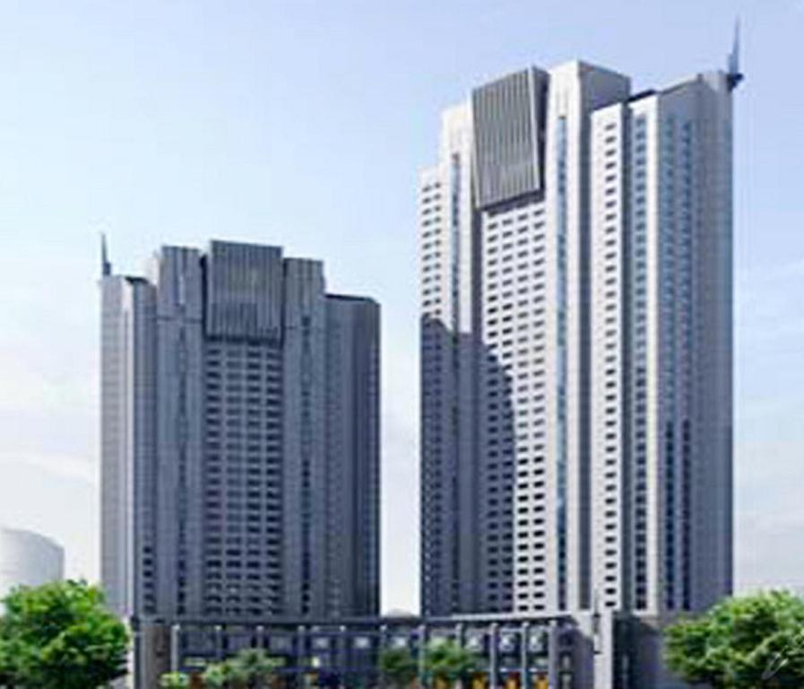 un grupo de edificios altos en una ciudad en Qingdao Housing International Hotel, en Qingdao