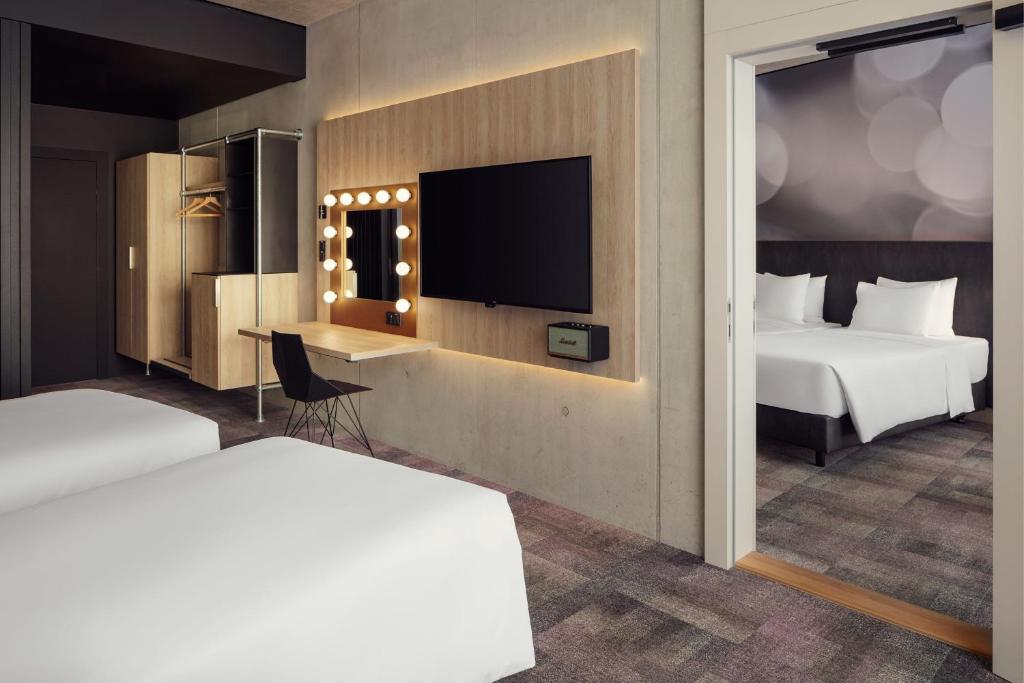 a hotel room with two beds and a flat screen tv at STAGES HOTEL Prague, a Tribute Portfolio Hotel in Prague