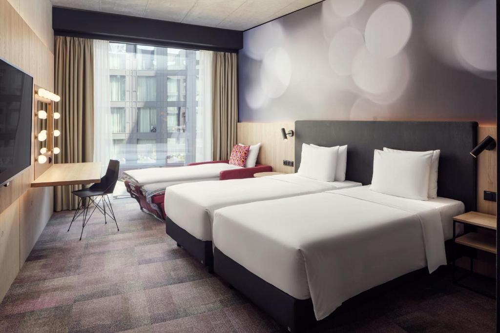 a hotel room with two beds and a desk at STAGES HOTEL Prague, a Tribute Portfolio Hotel in Prague