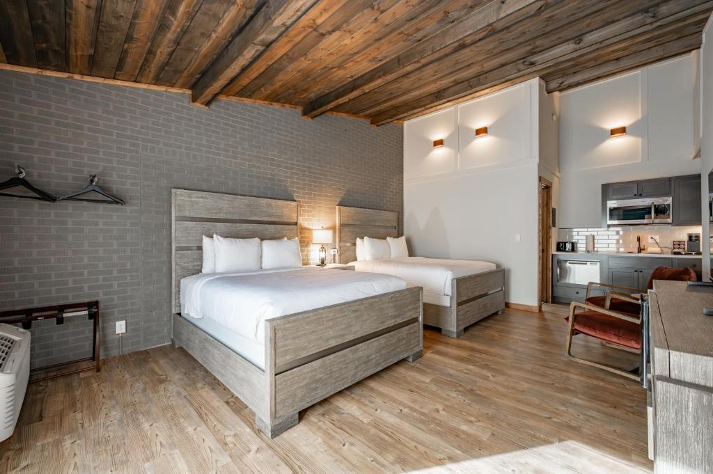 ein Schlafzimmer mit zwei Betten und eine Küche in einem Zimmer in der Unterkunft Cove Creek Lodge 216 Lakeside Double Queen Room in Oakland