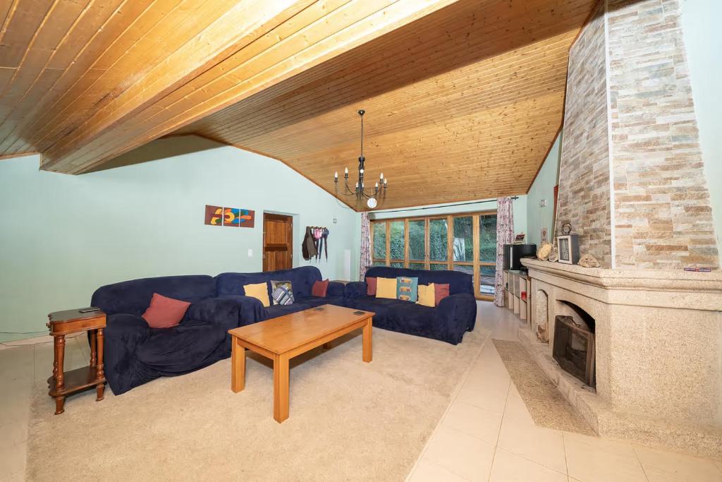 a living room with a blue couch and a fireplace at Yellow House - Casa Amarela in Oliveira do Hospital