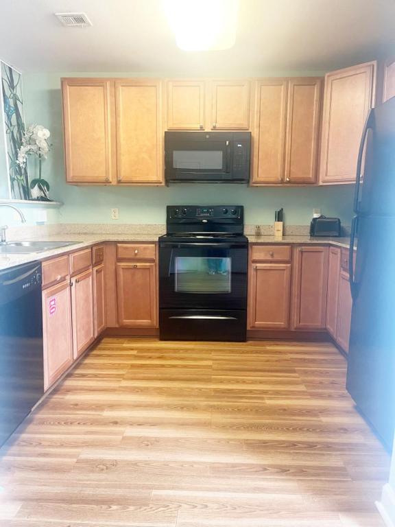 a kitchen with wooden cabinets and a black stove at Mountain View Condos - Unit 5105 in Pigeon Forge
