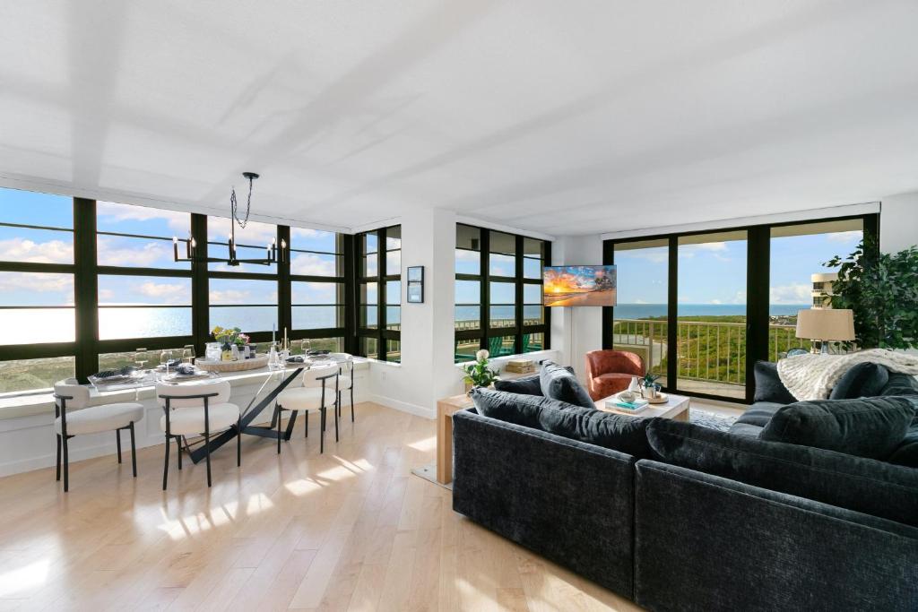 a living room with couches and a dining room with windows at La Bella Vita on Marco - 1812 South Seas Tower 3 in Marco Island