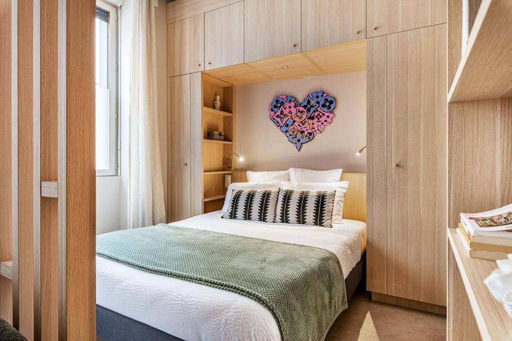 une chambre avec un lit avec un cœur sur le mur dans l'établissement Studio Standing - Centre-Ville, à Saint-Étienne