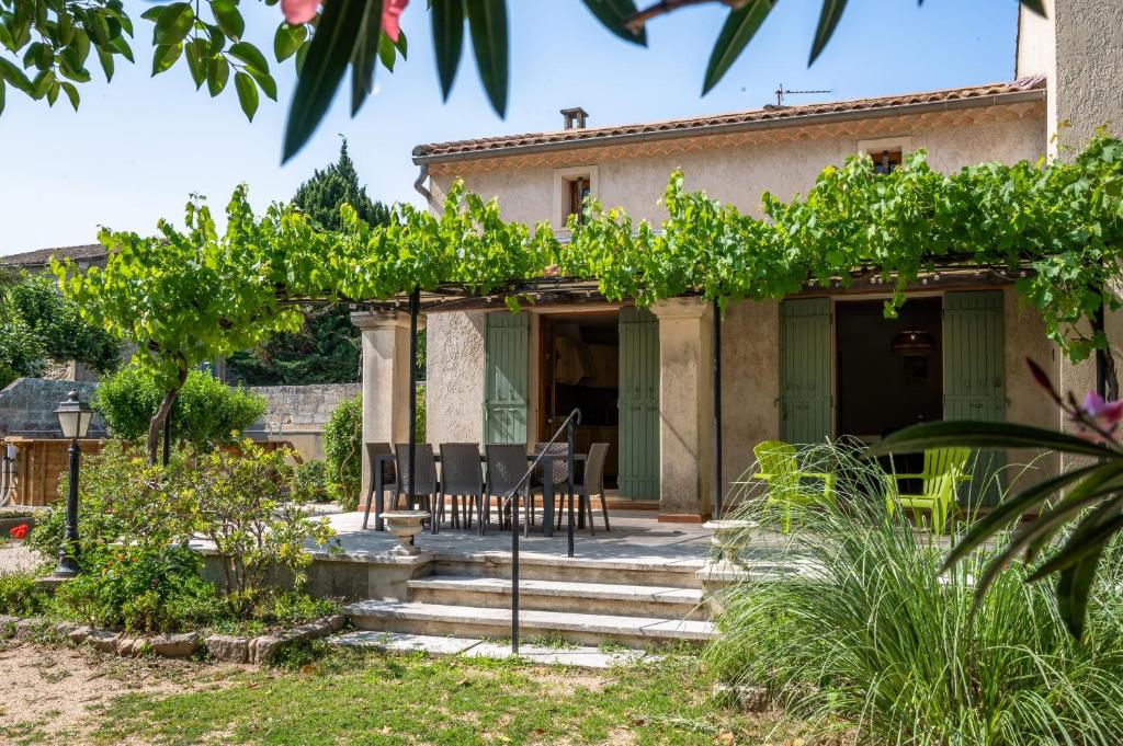 a home with a patio with a table and chairs at Villa Lou Pitchoun entre Les Alpilles et Avignon in Graveson