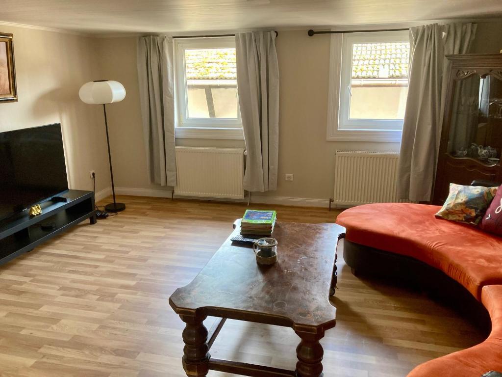 a living room with a red couch and a coffee table at Charmante maison de 140m2 au bord de la rivière au coeur de Wissembourg in Wissembourg