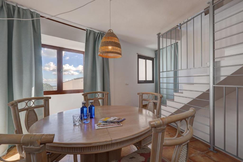 a dining room with a wooden table and chairs at Apartament Ewa z widokiem Casares in Casares