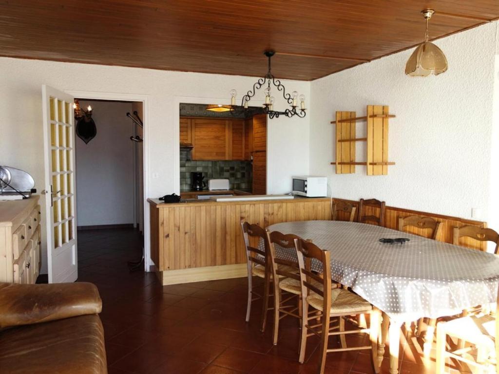 une cuisine et une salle à manger avec une table et des chaises dans l'établissement Résidence Majestic I - APPARTEMENT ALPE D'HUEZ QUARTIER VIEL ALPE MAE-2021, à Huez