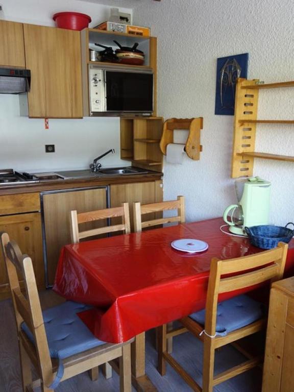 Il dispose d'une cuisine avec une table et des chaises rouges. dans l'établissement Résidence Maison De L'alpe - APPARTEMENT ALPE D'HUEZ QUARTIER VIEL ALPE MAE-2041, à Huez