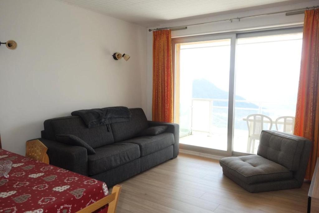 un salon avec un canapé et une chaise dans l'établissement Résidence Majestic Ii - APPARTEMENT ALPE D'HUEZ QUARTIER VIEL ALPE MAE-2091, à Huez
