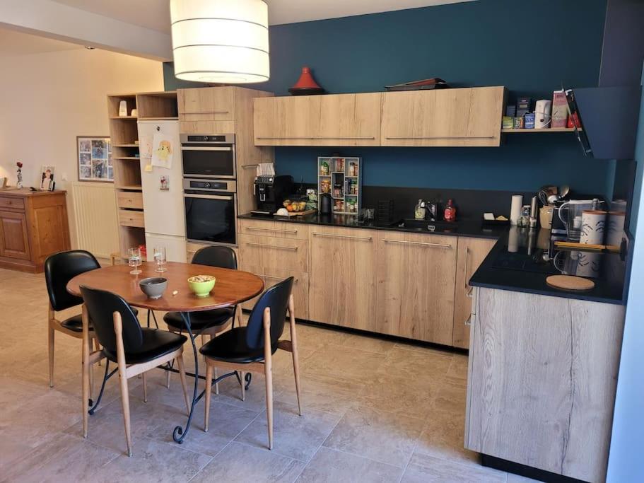 une cuisine avec une table et des chaises dans une cuisine dans l'établissement Charmant meublé de tourisme 4 étoiles, à Vals-les-Bains