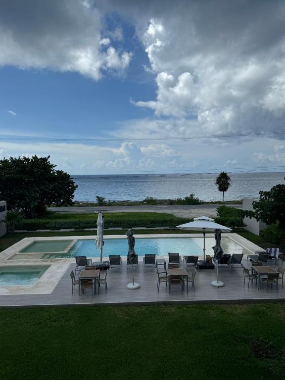 a patio with tables and chairs and a swimming pool at Deck 17 in Cozumel