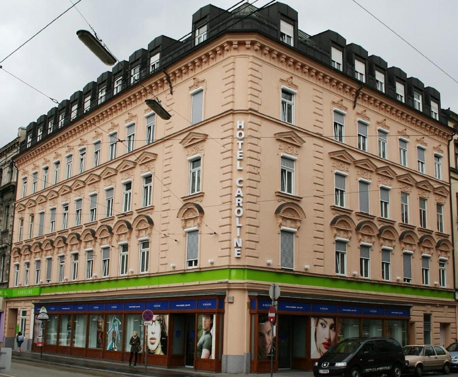a large building with a clock on the front of it at Hotel Caroline in Vienna