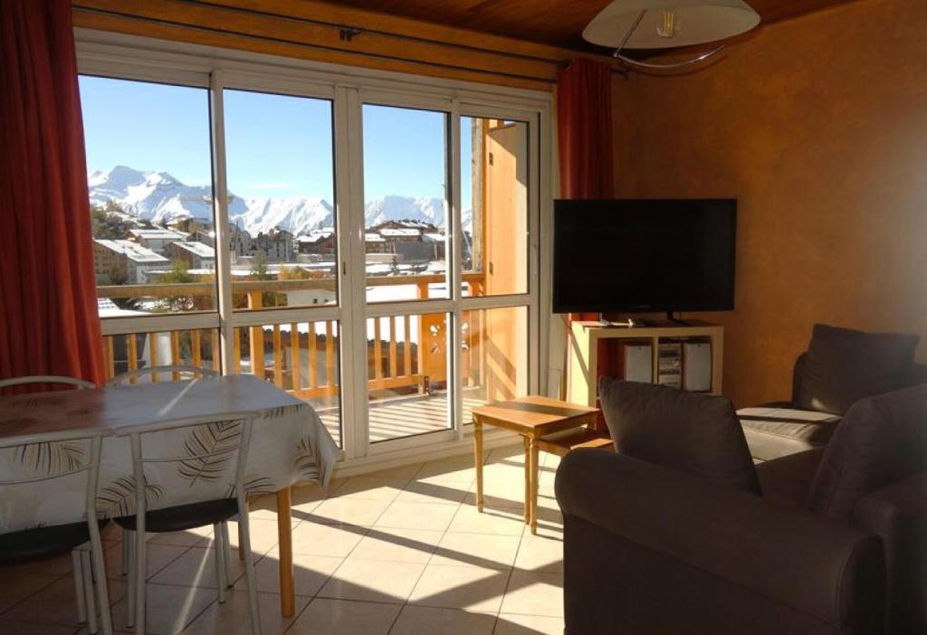 - un salon avec vue sur un balcon dans l'établissement Résidence Choucas - APPARTEMENT ALPE D'HUEZ QUARTIER CENTRE STATION MAE-2401, à Huez
