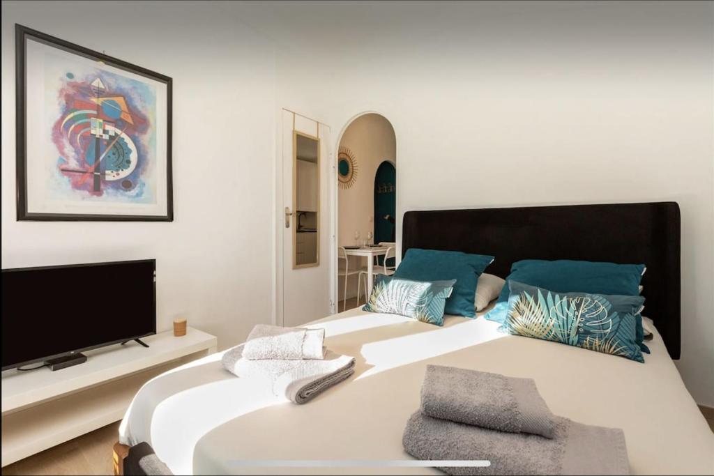 une chambre avec un grand lit avec une télévision à écran plat dans l'établissement Le Suquet - Château - Palais - Seaview - WIFI, à Cannes