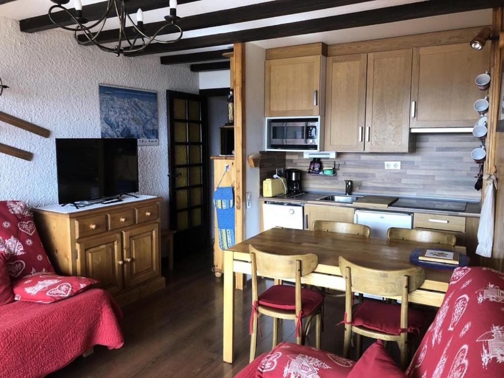 une petite cuisine avec une table et des chaises en bois dans l'établissement Résidence Gemeaux - APPARTEMENT ALPE D'HUEZ AVENUE DU RIF NEL MAE-2461, à Huez