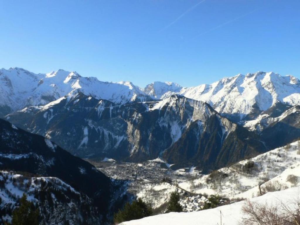 - une vue sur une chaîne de montagnes enneigée avec une ville dans l'établissement Résidence Vue Et Soleil - APPARTEMENT ALPE DHUEZ QUARTIER PASSEAUX MAE-2481, à Huez