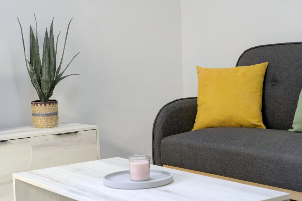 a couch with a yellow pillow and a candle on a table at Comeback SWEET HOME CALAHONDA in Calahonda