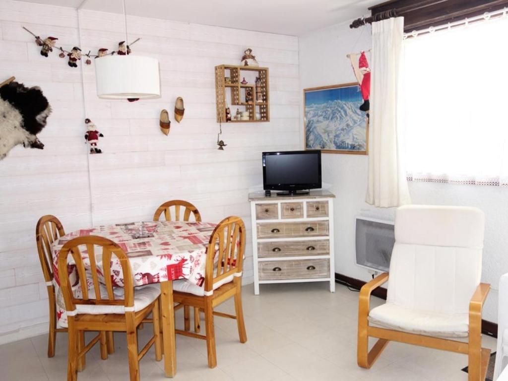 une salle à manger avec une table, des chaises et une télévision dans l'établissement Résidence Lupins - APPARTEMENT ALPE D'HUEZ QUARTIER CENTRE STATION MAE-2511, à Huez