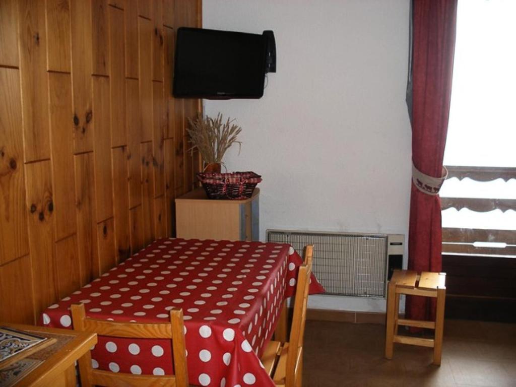 d'une salle à manger avec une table et une télévision murale. dans l'établissement Résidence Skival - APPARTEMENT ALPE D'HUEZ QUARTIER DE L'ECLOSE MAE-2551, à Huez