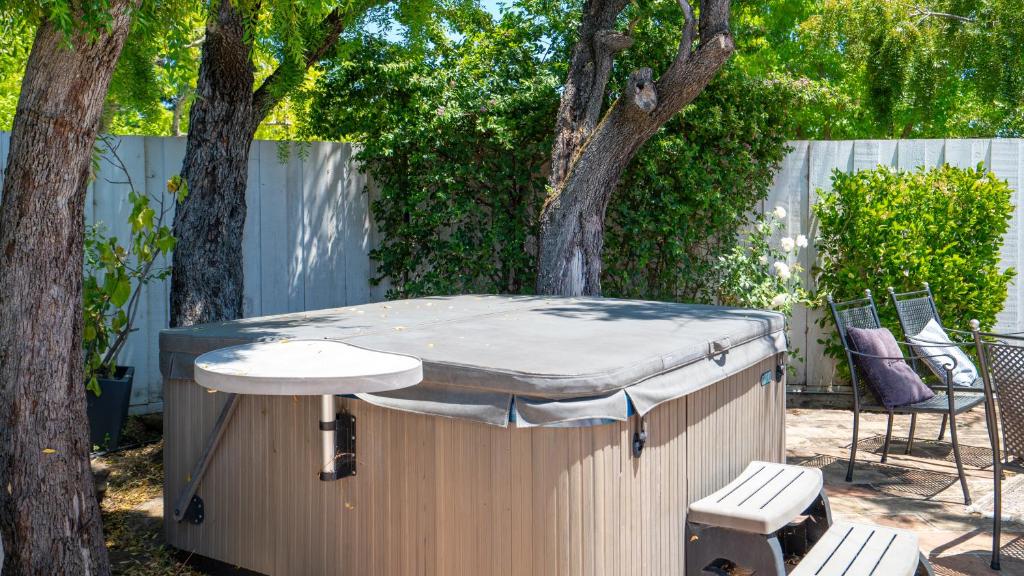 a hot tub in a backyard with two chairs and trees at Close to Wine Country,3bed ,2bath Pool, Hot-tub, Cold Plunge in San Rafael