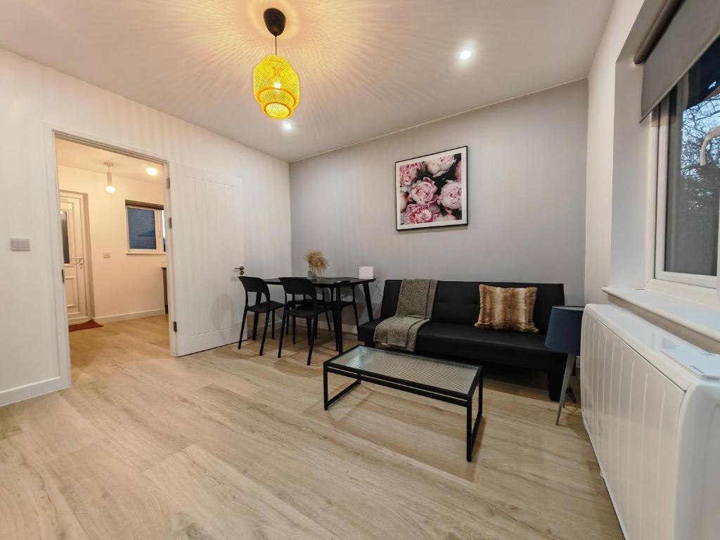 a living room with a couch and a table at 2 Bedroom Cotswold Bungalow in Castle Combe