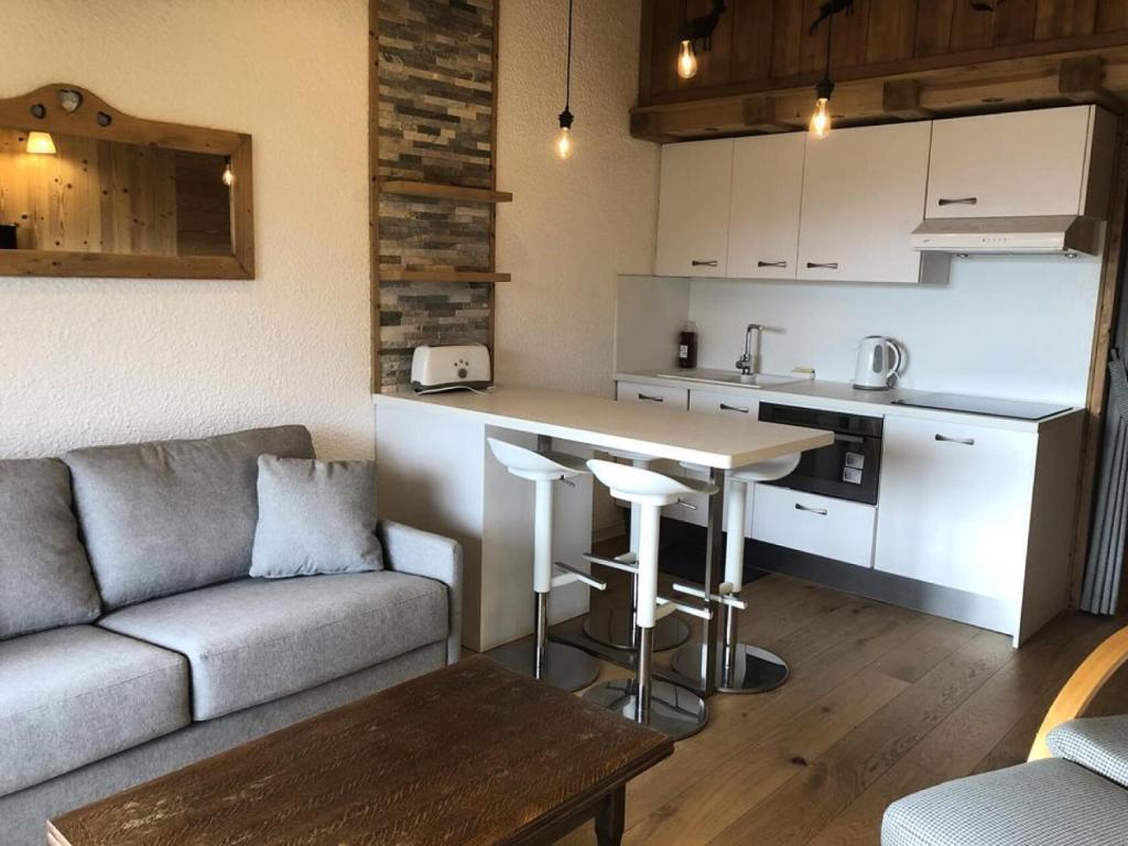 un salon avec un canapé et une cuisine dans l'établissement Résidence Richelieu - APPARTEMENT ALPE D'HUEZ RUE DU MAQUIS DE L'OISANS MAE-2691, à Huez