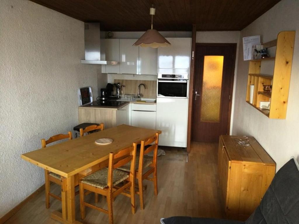 - une cuisine avec une table et des chaises en bois dans la chambre dans l'établissement Résidence Marmottes - APPARTEMENT 3 PIECES ALPE D'HUEZ CENTRE STAITON MAE-2781, à Huez