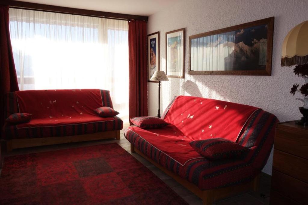 - un salon avec un canapé rouge et une fenêtre dans l'établissement Résidence Pleiades - STUDIO 30m2 ROUTE DU SIGNAL CENTRE STATION MAE-2841, à Huez