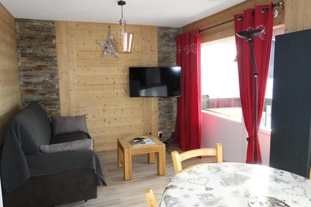 - un salon avec un canapé, une chaise et une télévision dans l'établissement Résidence Cabris - APPARTEMENT 3 PIECES- ALPE D'HUEZ COGNET-PIEDS DES PISTES MAE-2951, à Huez