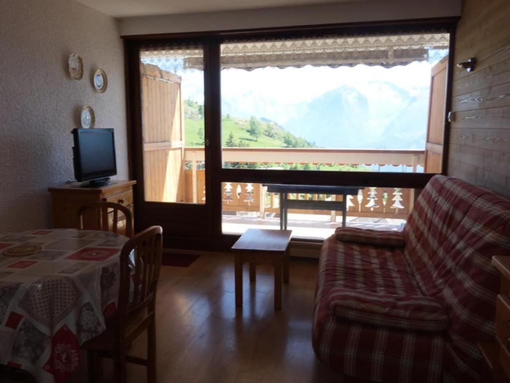 un salon avec un canapé, une table et une télévision dans l'établissement Résidence Maison De L'alpe - APPARTEMENT ALPE D'HUEZ-VIEL ALPE MAE-2991, à Huez