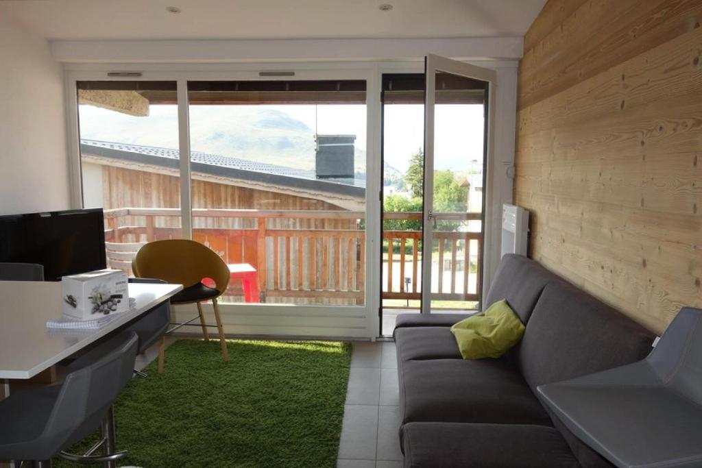 un salon avec un canapé, un bureau et une fenêtre dans l'établissement Résidence Milady - APPARTEMENT 2 PIECE + HALL HABITABLE ALPE D'HUEZ CENTRE STATION MAE-3001, à Huez