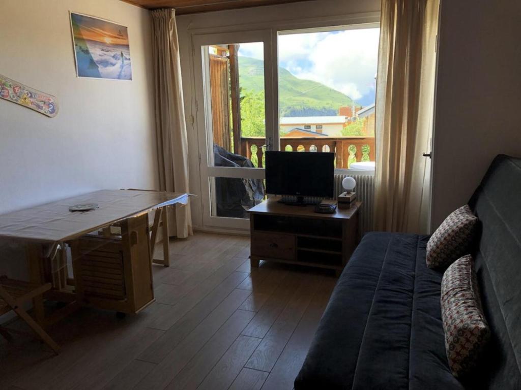 - un salon avec un canapé et un bureau avec une télévision dans l'établissement Résidence Saint Bernard - APPARTEMENT ALPE D'HUEZ CENTRE STATION MAE-3051, à Huez