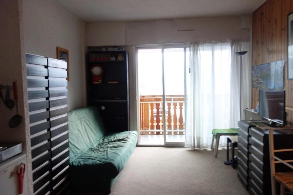 un salon avec un canapé et une porte coulissante en verre dans l'établissement Résidence Edelweiss - Studio + Hall Habitable de 25m² Quartier du Viel ALPE- MAE-3401, à Huez