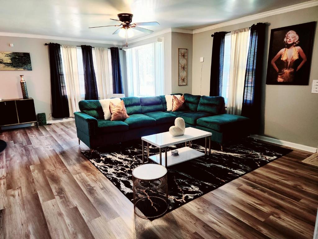 a living room with a green couch and a table at Chickasaw Landing in Chickasaw