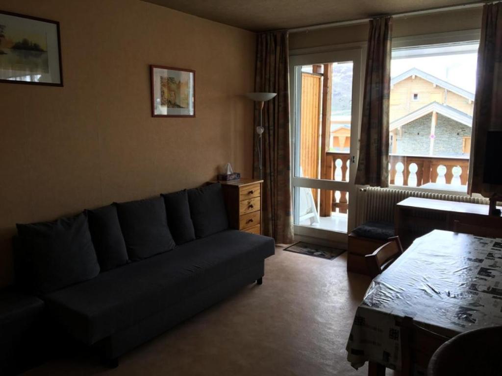 un salon avec un canapé et une grande fenêtre dans l'établissement Résidence Saint Bernard - APPARTEMENT ALPE D'HUEZ QUARTIER CENTRE STATION MAE-3471, à Huez