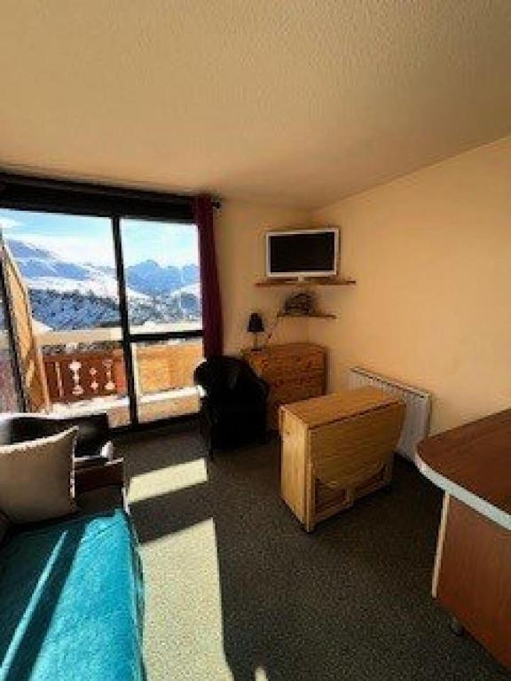 Cette chambre comprend un lit et une grande fenêtre. dans l'établissement Résidence Grand Sud - Appartement de 23m²-ALPE D'HUEZ ECLOSE EST MAE-3521, à Huez