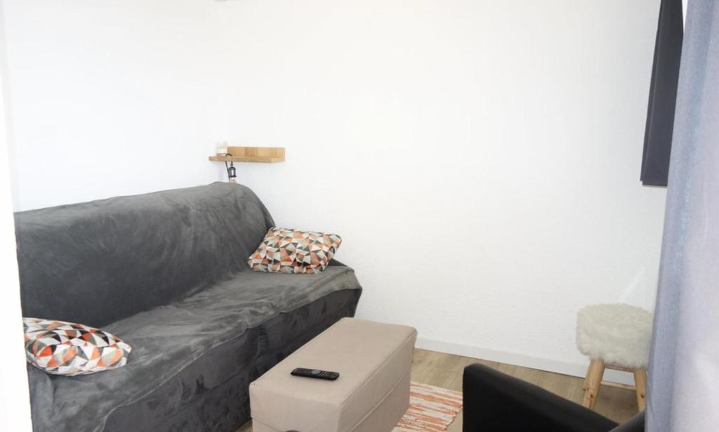 - un salon avec un canapé gris et une chaise dans l'établissement Résidence Balcons D'huez - APPARTEMENT ALPE D'HUEZ QUARTIER DE L'ECLOSE MAE-3601, à Huez