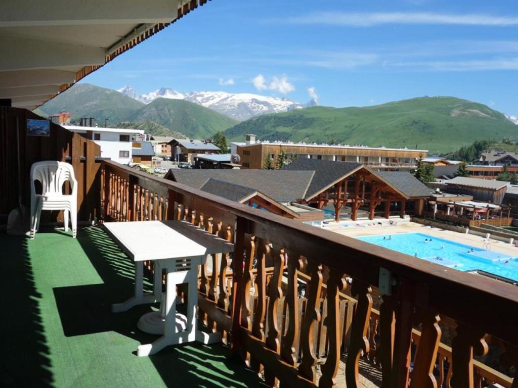 Elle comprend un balcon offrant une vue sur la piscine et les montagnes. dans l'établissement Résidence Menandiere - APPARTEMENT 3 PIECES ALPE D'HUEZ CENTRE STATION MAE-3651, à Huez